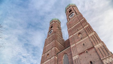 Photo for Frauenkirche Church exterior of building in Old Town Square in Munich looking up perspective timelapse. The famous church is a landmark and is considered a symbol of the Bavarian capital city. Germany - Royalty Free Image