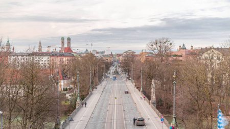 Photo for Panoramic aerial view from Maximilianeum timelapse with driving cars and tramway on Maximilian Bridge and Maximilianstrasse, Munich, Germany. Famous landmarks in a distance - Royalty Free Image