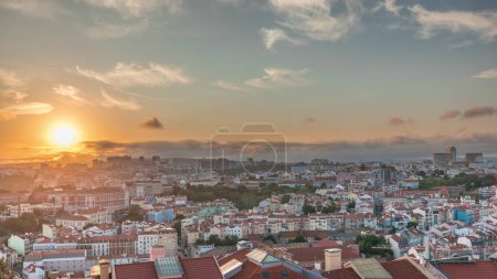 Panorama, das Lissabon berühmte Luftaufnahme vom Miradouro da Senhora do Monte touristischen Aussichtspunkt der Alfama und Mauraria Altstadt Zeitraffer zeigt, rote Dächer bei Sonnenuntergang. Dramatischer Himmel. Lissabon, Portugal