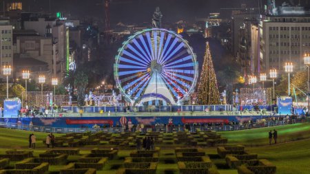 Téléchargez les photos : Grande roue à l'intérieur de l'événement traditionnel de Noël au Parque Eduardo VII timelapse dans la ville de Lisbonne au Portugal. Les gens patinent près du sapin de Noël. Vue d'en haut - en image libre de droit