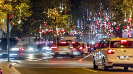 Foto de Avenida da Liberdade en Lisboa iluminada con luces colgando de los árboles por la noche timelapse. Tráfico en la carretera durante la noche de vacaciones. Calle europea decorada para la celebración de Navidad. Portugal - Imagen libre de derechos