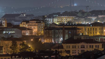 Téléchargez les photos : Vue aérienne en direction de Barrio Alto et du pont du 25 avril dans la nuit, Lisbonne, Portugal. Bâtiments historiques colorés avec éclairage du soir - en image libre de droit