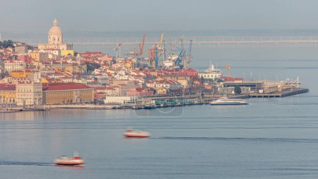 Photo for Panorama of Lisbon historical center terreiro do paco aerial timelapse viewed from above the southern margin of the Tagus or Tejo River. Buildings with red roofs and floating ships at ferry terminal - Royalty Free Image