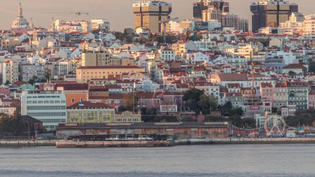 Luftaufnahme der Skyline von Lissabon mit den schießenden Türmen von Amoreiras. Historische Gebäude in der Nähe des Bezirks Santos, Docks und der Fluss Tejo liegen im Zeitraffer von Almada am südlichen Rand bei Sonnenuntergang. Lissabon, Portugal