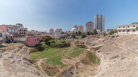 Photo for Panorama showing the Amphitheatre of Durres (Amphitheatrum Dyrrhachium) timelapse from above. Ruins of the ancient Roman amphitheatre in the center of Durres, Albania. - Royalty Free Image