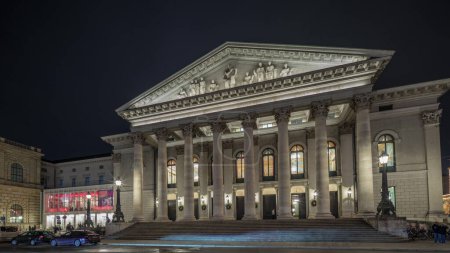 Photo for Munich National Theatre or Nationaltheater on the Max Joseph square night timelapse hyperlapse. Illuminated historic opera house front view, home of the Bavarian State Opera. Germany - Royalty Free Image