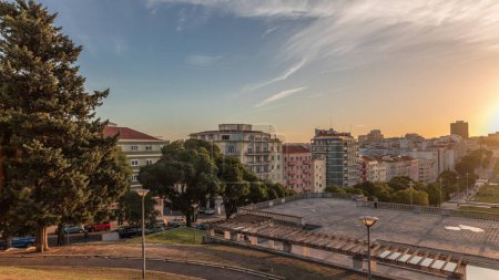 Téléchargez les photos : Panorama montrant le coucher du soleil sur la pelouse à Alameda Dom Afonso Henriques avec des bâtiments colorés et la fontaine lumineuse intemporelle aérienne. Vue d'en haut avec ciel nocturne à Lisbonne, Portugal - en image libre de droit