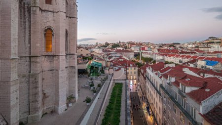 Photo for Panorama showing Alfama and Baixa districts of Lisbon aerial day to night transition timelapse, Portugal, with the panoramic terrace of historical Santa Justa lift, old iron elevator from above - Royalty Free Image