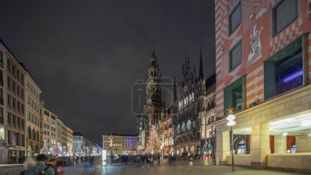 Photo for Marienplazt Old Town Square with New Town Hall night timelapse hyperlapse. Neues Rathaus and Town Hall Clock Tower Glockenspiel. Munich skyline, downtown cityscape. Rainy weather. Bavaria, Germany - Royalty Free Image