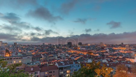 Téléchargez les photos : Panorama montrant la vue aérienne du centre-ville de Lisbonne de jour à nuit timelapse de transition, Portugal. Toits rouges de maisons typiques dans la vieille ville skyline. Quartier historique après le coucher du soleil dans la capitale - en image libre de droit