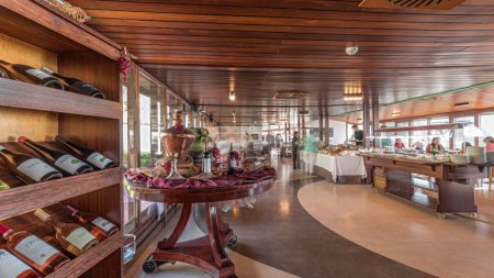 Photo for Panorama showing morning catering buffet food indoor in luxury restaurant with meat, colorful fruits and vegetables timelapse. Bottles of wine and many tables with different food during the breakfast - Royalty Free Image