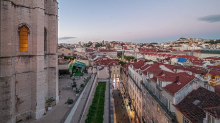 Photo for Panorama showing Alfama and Baixa districts of Lisbon aerial day to night transition timelapse, Portugal, with the panoramic terrace of historical Santa Justa lift, old iron elevator from above - Royalty Free Image