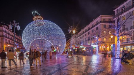 Foto de Panorama mostrando decoraciones navideñas con gran bola en la plaza Luis De Camoes (Praca Luis de Camoes) timelapse nocturno. Una de las plazas más grandes de la ciudad de Lisboa en Portugal iluminada por la noche - Imagen libre de derechos