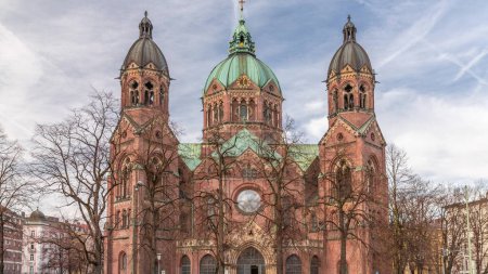 Timelapse de la iglesia de St. Luke (St. Lukas o Lukaskirche), la iglesia protestante más grande en Munich, Alemania meridional. Cielo nublado y tráfico en la calle