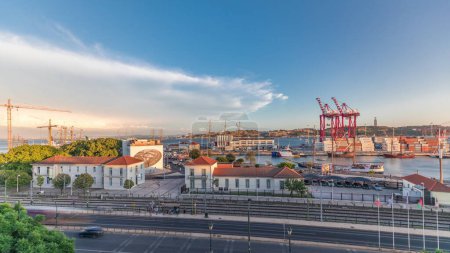 Foto de Panorama que muestra la vista aérea de los barcos en el muelle en el puerto de la ciudad de Lisboa timelapse con el 25 de abril Puente en el fondo. Tráfico en la avenida durante el atardecer desde arriba - Imagen libre de derechos
