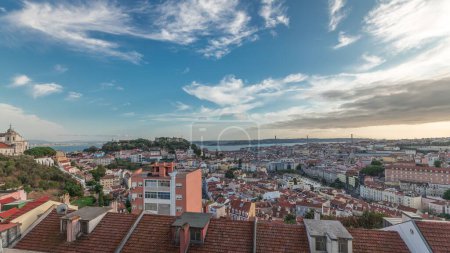 Photo for Panorama showing Lisbon famous aerial view from Miradouro da Senhora do Monte highest viewpoint of Alfama and Mauraria old city district timelapse, 25th of April Bridge before sunset. Lisbon, Portugal - Royalty Free Image