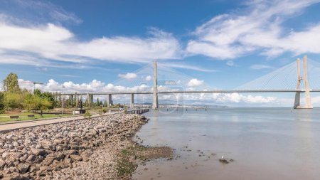 Téléchargez les photos : Panorama montrant le front de mer et le pont Vasco da Gama timelapse. Pont à haubans le plus long flanqué de viaducs et offrant une vue sur le Tage dans le Parc des Nations de Lisbonne, Portugal - en image libre de droit