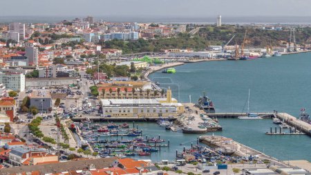 Foto de Vista aérea del puerto deportivo y el timelapse del centro de la ciudad en Setúbal, Portugal. Techos rojos y paseo marítimo con barcos y barcos de arriba. Tráfico en la carretera - Imagen libre de derechos