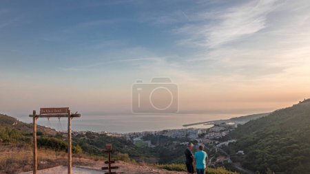 Téléchargez les photos : Panorama montrant la vue aérienne de la ville de Sesimbra et du port pendant le coucher du soleil timelapse, Portugal. Paysage du soir avec château sur la colline du point de vue avec une balançoire. Resort dans le quartier de Setubal - en image libre de droit