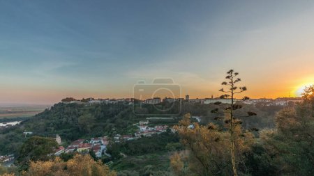 Panorama que muestra la puesta de sol sobre el castillo de Almourol en la colina en Santarem timelapse aéreo. Un castillo medieval sobre el islote de Almourol en medio del río Tajo y casas. Portugal