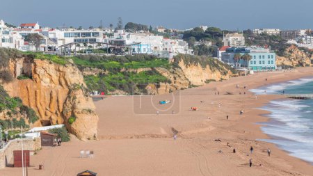 Foto de Amplia playa de arena y océano Atlántico en la ciudad de Albufeira timelapse. Casas blancas en la cima de los acantilados. Vista aérea desde arriba. Algarve, Portugal - Imagen libre de derechos