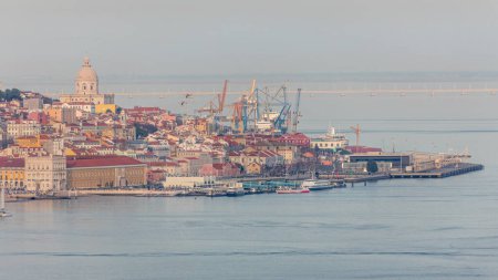 Photo for Panorama of Lisbon historical center terreiro do paco aerial timelapse viewed from above the southern margin of the Tagus or Tejo River. Buildings with red roofs and floating ships at ferry terminal - Royalty Free Image
