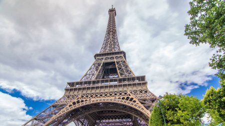 Photo for Champ de Mars and the Eiffel Tower timelapse hyperlapse in a sunny summer day. Paris, France. Green trees and cloudy sky. Moving back - Royalty Free Image