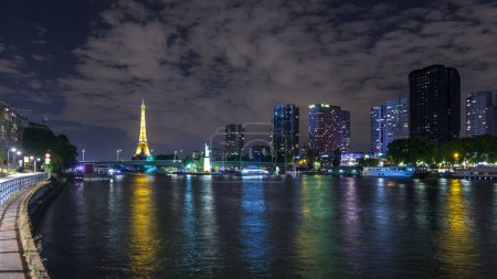 Foto de Panorama con la pequeña Estatua de la Libertad situada cerca del timelapse nocturno de la torre Eiffel. Puente Grenelle sobre fondo y edificios modernos. París, Francia - Imagen libre de derechos