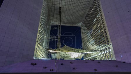 Téléchargez les photos : Vue de nuit du quartier des affaires de la Défense à Paris timelapse hyperlapse. Des gens assis dans les escaliers le soir. Paris, France - en image libre de droit