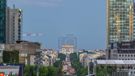 Photo for View from above in Defense business district to the Arc de Triumph day to night transition timelapse. Illuminated skyscrapers and traffic on road after sunset. Paris, France - Royalty Free Image