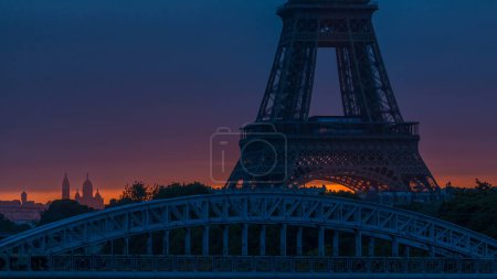Téléchargez les photos : Tour Eiffel lever du soleil timelapse avec des bateaux sur la Seine et à Paris, France. Vue depuis le pont Grenelle. Vue rapprochée avec grand soleil rouge passant sous la tour - en image libre de droit