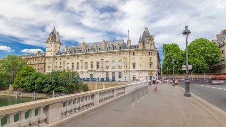 Téléchargez les photos : Immeuble de la Cour de cassation et de la circulation sur le pont Saint-Michel hyperlapsus timelapse à Paris, France. Arbres verts, randonneurs et ciel nuageux le jour d'été - en image libre de droit