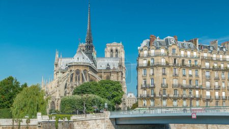 Foto de Notre Dame de Paris parte trasera timelapse. Uno de los símbolos más famosos de París. Puente de Saint-Louis. Vista desde el paseo marítimo de Siene en el soleado día de verano - Imagen libre de derechos