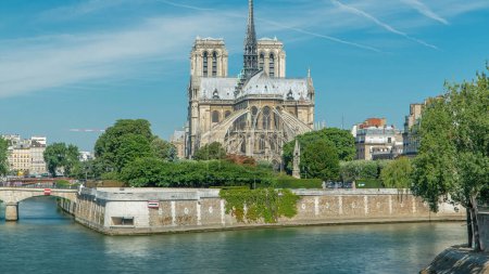 Foto de Notre Dame de Paris parte trasera timelapse. Uno de los símbolos más famosos de París. Vista desde el puente Tournelle con barcos en el río Siene en el soleado día de verano - Imagen libre de derechos