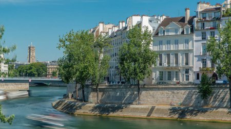 Photo for Saint-Louis bridge timelapse with houses on Orleans waterfront. Two islands on the River Seine in Paris, France, called Ile de la cite and Ile saint Louis. Tower on a background. Paris, France. - Royalty Free Image