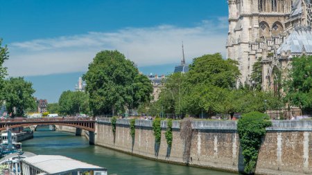 Foto de Sena con Puente Doble y Notre Dame de Paris timelapse. Uno de los símbolos más famosos de París. Vista desde el Puente del Arzobispado con estación de barco en el soleado día de verano - Imagen libre de derechos