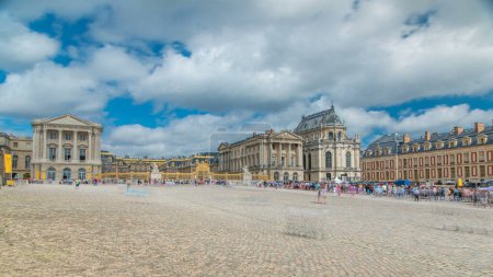 Téléchargez les photos : Entrée principale et façade du château de Versailles timelapse avec les touristes. Versailles, France. Les gens font la queue. Ciel bleu nuageux le jour d'été - en image libre de droit