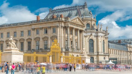 Téléchargez les photos : Porte dorée dans le château de Versailles timelapse avec les touristes vue de près. Versailles, France. Les gens font la queue. Ciel bleu nuageux le jour d'été - en image libre de droit