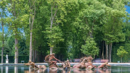 Foto de Fuente Apolo en el timelapse del parque del Palacio de Versalles, Isla de Francia. Árboles verdes sobre fondo con reflexión sobre el agua - Imagen libre de derechos