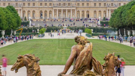 Foto de Famoso palacio Versalles con hermosos jardines timelapse de la fuente de Apolo. El Palacio de Versalles era un castillo real. Personas en el parque y en las escaleras. París, Francia. - Imagen libre de derechos