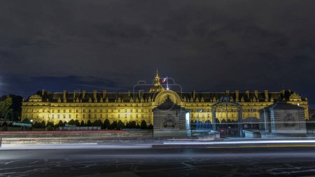 Téléchargez les photos : Les Invalides avec drapeau français sur le dessus la nuit illumination timelapse hyperlapse à Paris, France. Trafic routier près des portes en été - en image libre de droit