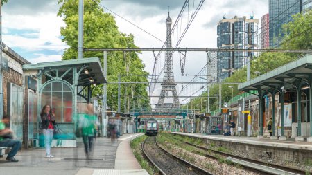 Foto de Estación de tren de Javel con torre Eiffel en el timelapse de fondo. Estación de ferrocarril francesa en la línea de los Inválidos situada en el distrito 15 de París, en el distrito de Javel. Cielo nublado. Francia - Imagen libre de derechos