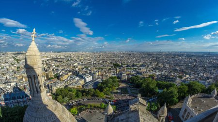Téléchargez les photos : Panorama de Paris d'en haut timelapse, France. Vue aérienne du dessus depuis le point de vue de Montmartre. Des gens marchant dans le parc. Journée ensoleillée avec ciel nuageux bleu. - en image libre de droit