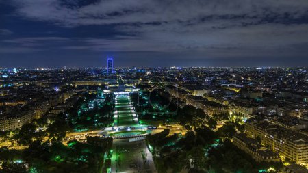 Photo for Aerial Night timelapse view of Paris City and Field of Mars shot on the top of Eiffel Tower observation deck. Evening illumination from above - Royalty Free Image