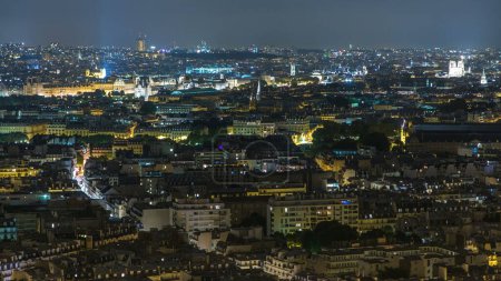 Téléchargez les photos : Vue aérienne de nuit de la ville de Paris et de la Seine prise sur le pont d'observation de la Tour Eiffel. Illumination nocturne de nombreuses rues - en image libre de droit