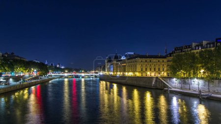 Foto de Cite isla vista aérea con Conciergerie Castillo y Pont au Change, sobre el río Sena timelapse hiperlapso. Iluminación nocturna reflejada en el agua. Francia, París - Imagen libre de derechos