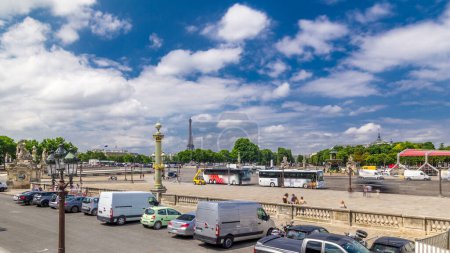 Photo for Fontaines de la Concorde and Luxor Obelisk at the center of Place de la Concorde timelapse hyperlapse in Paris, France. Traffic on a road and Eiffel tower on background. Blue cloudy sky at summer day - Royalty Free Image