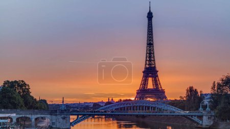 Foto de Torre Eiffel timelapse amanecer con barcos en el río Sena y en París, Francia. Vista desde el puente Grenelle. Cielo naranja temprano en la mañana - Imagen libre de derechos