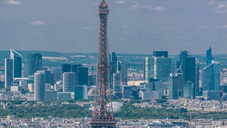 Téléchargez les photos : Vue aérienne depuis la tour Montparnasse avec la tour Eiffel et le quartier des affaires de La Défense sur fond de timelapse à Paris, France. Vue de dessus de la terrasse d'observation à la journée ensoleillée d'été. - en image libre de droit