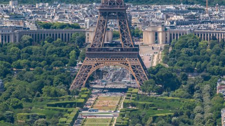 Photo for Aerial view from Montparnasse tower with Eiffel tower basement and Champ de Mars timelapse in Paris, France. Top view from observation deck at sunny summer day. - Royalty Free Image